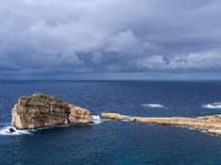 Dunkle Regenfront hinter dem Fungus Rock in der Dwejra Bay - Gozo